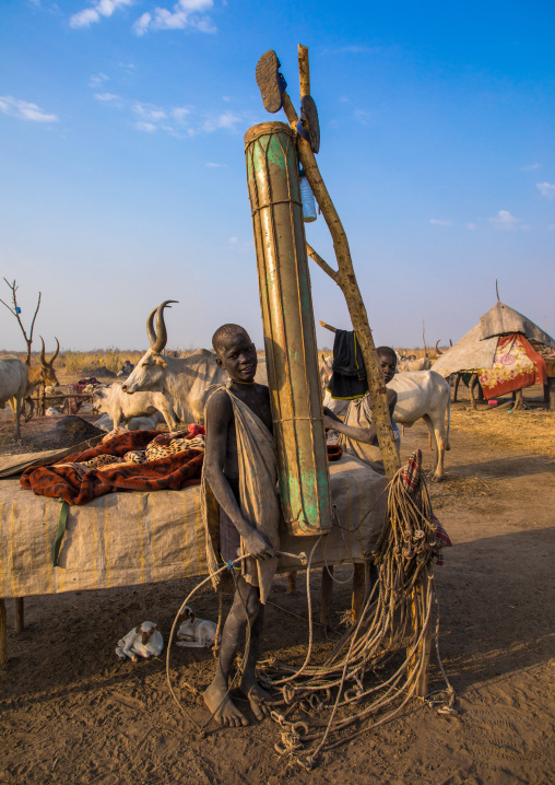 Mundari tribe boy in front of a long drum in a cattle camp, Central Equatoria, Terekeka, South Sudan