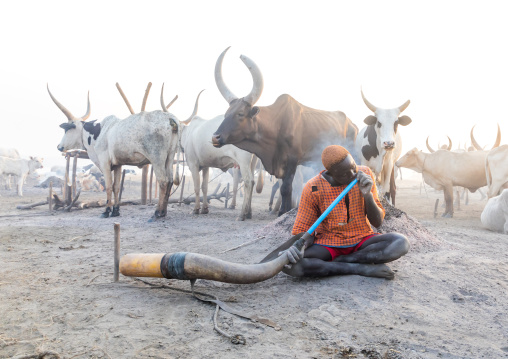 Mundari tribe man blowing in a cow horn, Central Equatoria, Terekeka, South Sudan