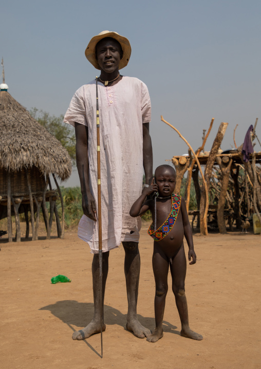 Mundari tribe father with his son using a mobile phone, Central Equatoria, Terekeka, South Sudan
