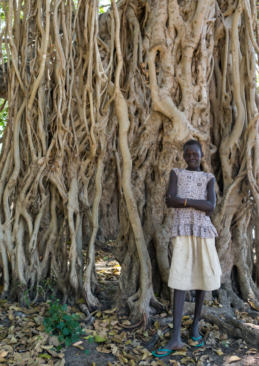 Girl standing in front of a huge tree, Central Equatoria, Terekeka, South Sudan
