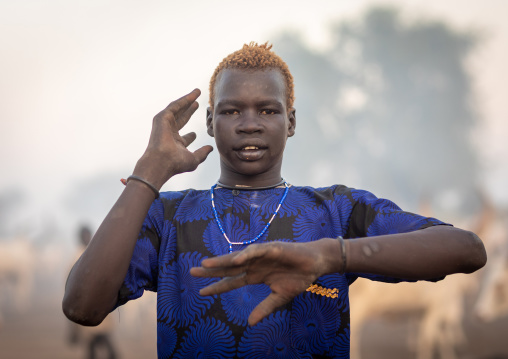 Portrait of a Mundari tribe man mimics the position of horns of his favourite cow, Central Equatoria, Terekeka, South Sudan