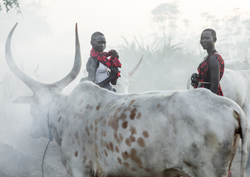 Mundari tribe woman with long horns cows in a camp, Central Equatoria, Terekeka, South Sudan