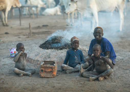 Mundari tribe boys taking care of the bonfires made with dried cow dungs to repel flies and mosquitoes, Central Equatoria, Terekeka, South Sudan