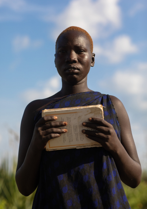 Portrait of a Mundari tribe woman holding a book, Central Equatoria, Terekeka, South Sudan