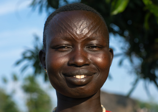 Portrait of a smiling Mundari tribe woman with scarifications on the forehead, Central Equatoria, Terekeka, South Sudan