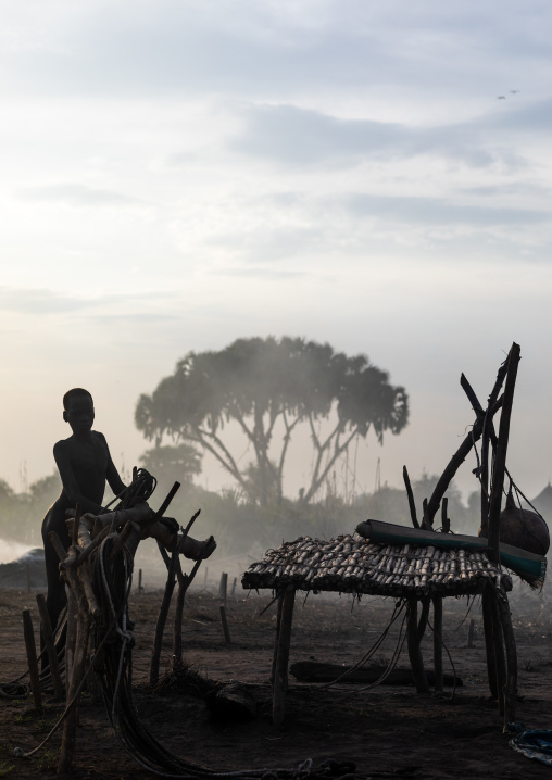 Mundari tribe boy in the smoke of the bonfires used to repel the mosquitoes, Central Equatoria, Terekeka, South Sudan