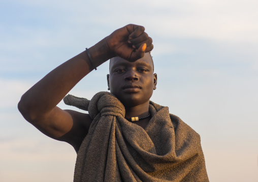 Portrait of a Mundari tribe man mimics the position of horns of his favourite cow, Central Equatoria, Terekeka, South Sudan