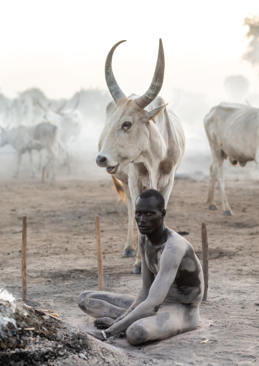 Mundari tribe man taking care of the bonfires made with dried cow dungs to repel mosquitoes and flies, Central Equatoria, Terekeka, South Sudan
