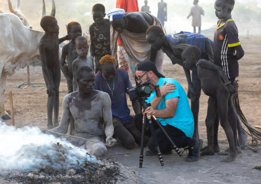 Tourist showing pictures to Mundari tribe men, Central Equatoria, Terekeka, South Sudan