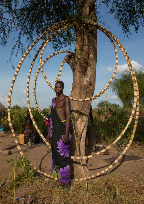Portrait of a Mundari tribe woman in front of stuff used to build the huts, Central Equatoria, Terekeka, South Sudan