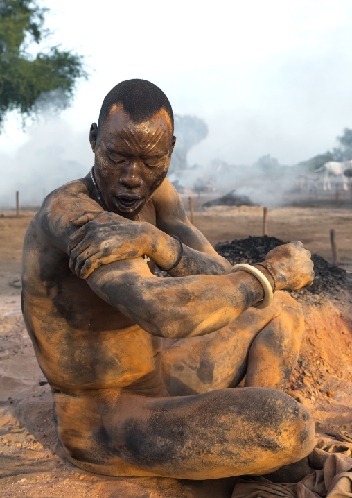 Mundari tribe man covering his body in ash to repel flies and mosquitoes, Central Equatoria, Terekeka, South Sudan