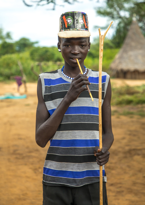 Larim tribe boy with a fashionnable look using a wooden toothbrush, Boya Mountains, Imatong, South Sudan