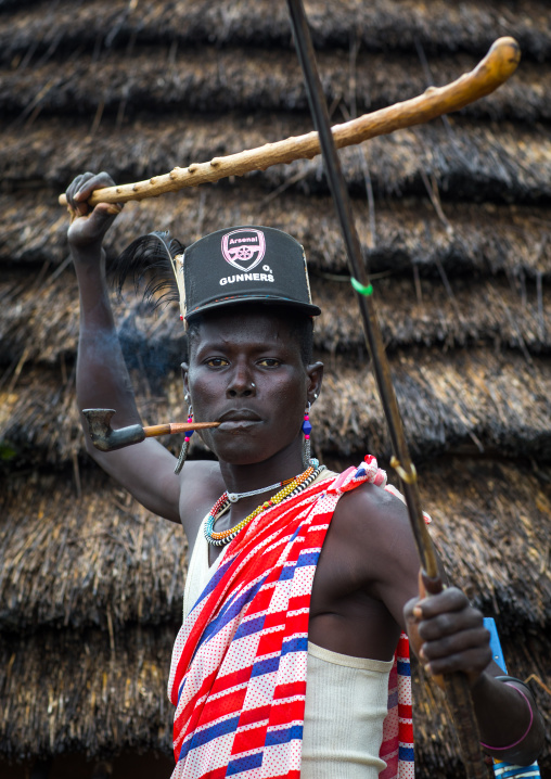 Larim tribe boy with a fashionnable look using a fighting stick, Boya Mountains, Imatong, South Sudan