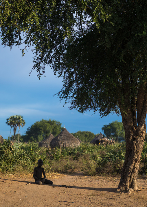 Mundari boy sit under the shade of a big tree, Central Equatoria, Terekeka, South Sudan