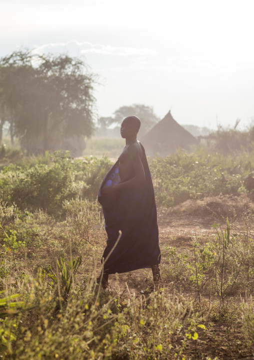 Mundari tribe woman walking in the bush, Central Equatoria, Terekeka, South Sudan