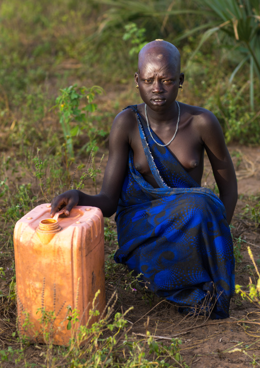 Portrait of a Mundari tribe teenage girl with a jerrican full of water, Central Equatoria, Terekeka, South Sudan