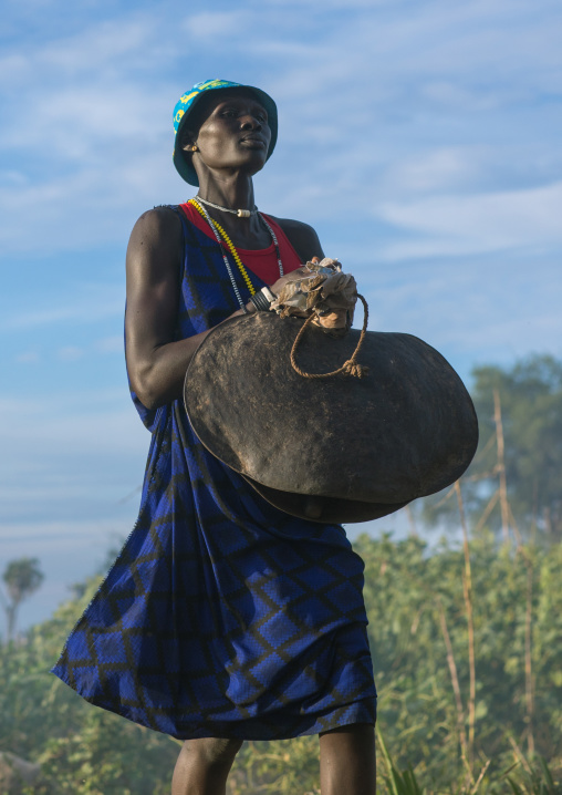Mundari tribe woman carrying a huge bell while celebrating a wedding, Central Equatoria, Terekeka, South Sudan