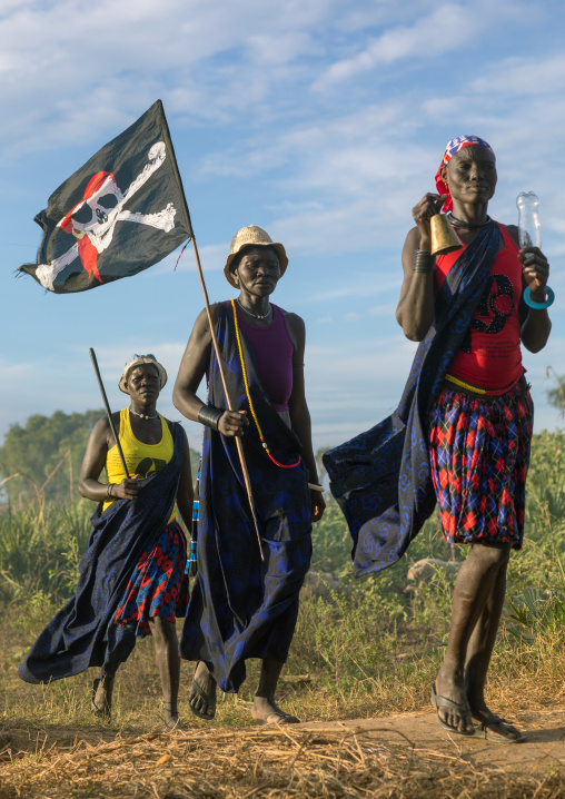 Mundari tribe women marching in line with a pirate flag while celebrating a wedding, Central Equatoria, Terekeka, South Sudan