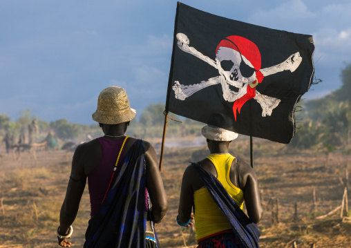 Mundari tribe women marching in line with a pirate flag while celebrating a wedding, Central Equatoria, Terekeka, South Sudan
