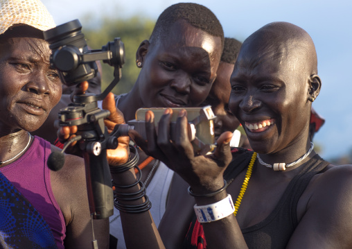 Mundari tribe women laughing while watching themsleves on the screen of a camera, Central Equatoria, Terekeka, South Sudan