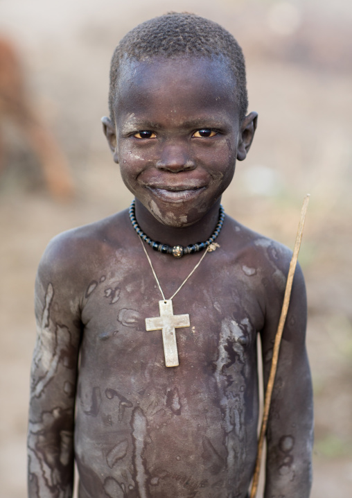 Mundari tribe boy with a christian cross covered in ash to protect from the mosquitoes and flies, Central Equatoria, Terekeka, South Sudan