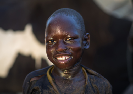 Smiling Mundari tribe boy after showering in the cow urine to dye his hair in orange, Central Equatoria, Terekeka, South Sudan
