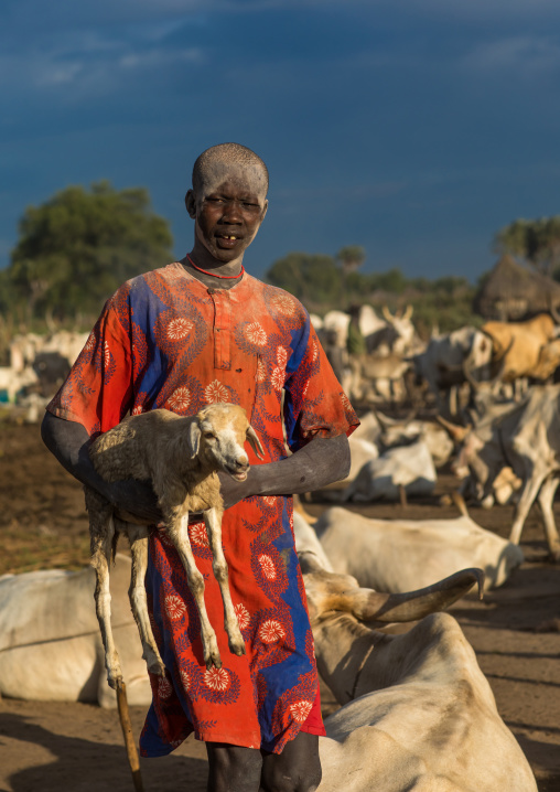 Portrait of a Mundari tribe man carrying a young sheep, Central Equatoria, Terekeka, South Sudan