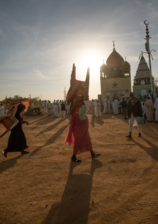 Woman bringing chairs for the friday sufi celebration at sheikh Hamad el nil tomb, Khartoum State, Omdurman, Sudan