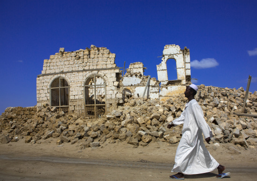 Sudan, Port Sudan, Suakin, man passing in front of a ruined ottoman coral buildings