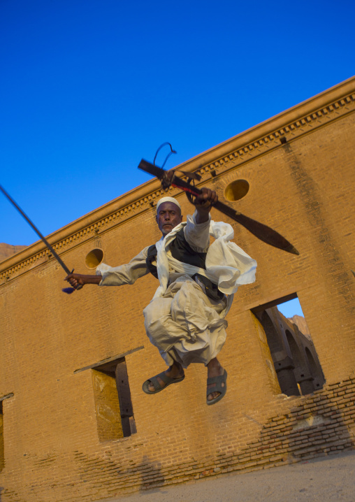 Sudan, Kassala State, Kassala, beja tribe man dancing in front of the khatmiyah mosque at the base of the taka mountains