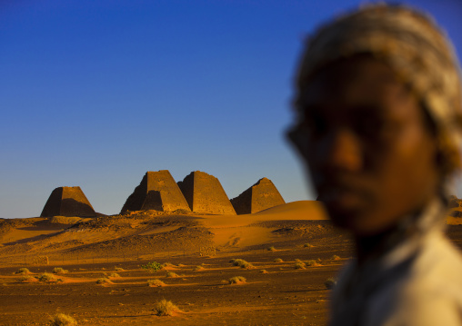 Sudan, Kush, Meroe, kid in front of the pyramids and tombs in royal cemetery
