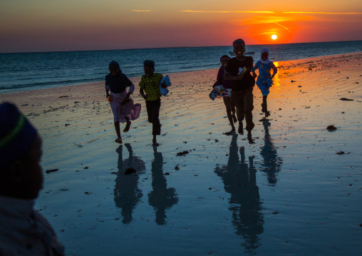 Tanzania, Zanzibar, Kizimkazi, young muslim children on beach during sunset