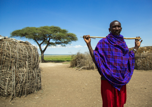 Tanzania, Ashura region, Ngorongoro Conservation Area, maasai man with a stick outside his home