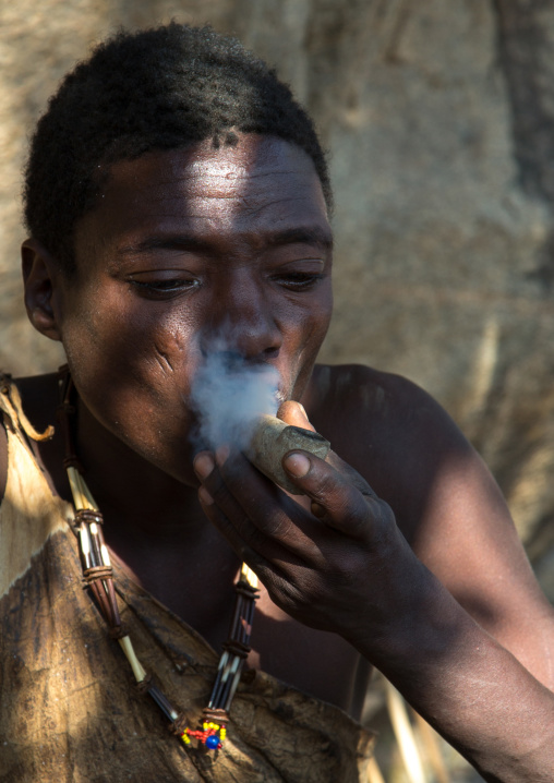 Tanzania, Serengeti Plateau, Lake Eyasi, hadzabe tribe man smoking cannabis