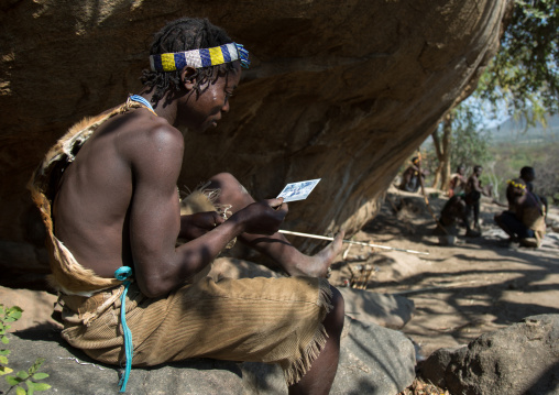 Tanzania, Serengeti Plateau, Lake Eyasi, hadzabe tribe man discovering his face on a polaroid