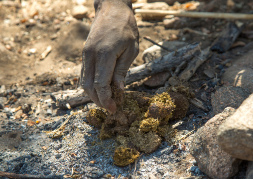 Tanzania, Serengeti Plateau, Lake Eyasi, hadzabe tribe using animal dungs to make fire