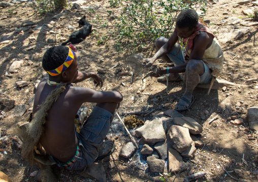 Tanzania, Serengeti Plateau, Lake Eyasi, hadzabe tribe men making fire with animal dungs