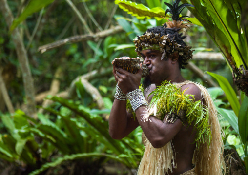 Tribal man blowing conch shell during a cultural show, Efate Island, Port Vila, Vanuatu
