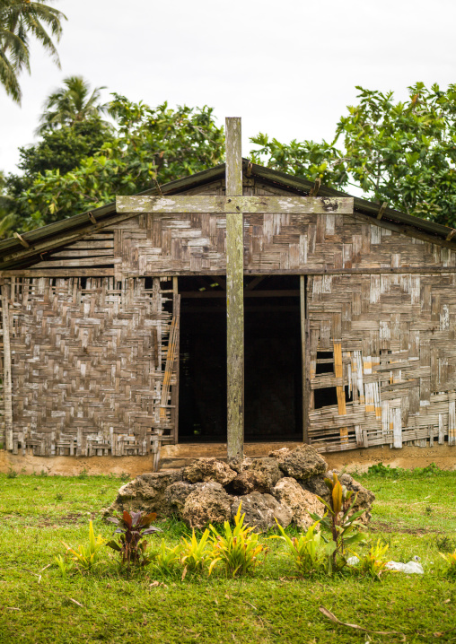 Tomb with a cross in front of a traditional house made with palm leaves, Malampa Province, Malekula Island, Vanuatu