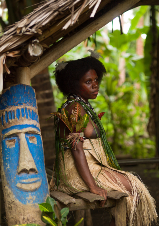 Small Nambas tribeswoman during the palm tree dance sit near a statue, Malekula island, Gortiengser, Vanuatu