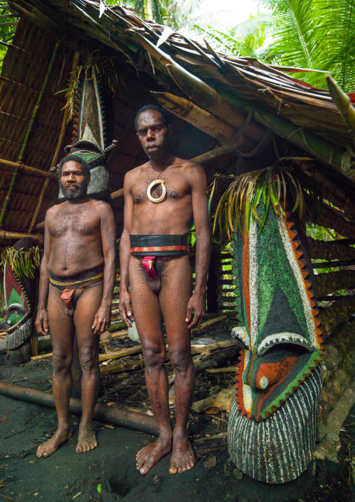 Portrait of chieftain Sekor and his father in front of a painted grade statue, Ambrym island, Olal, Vanuatu
