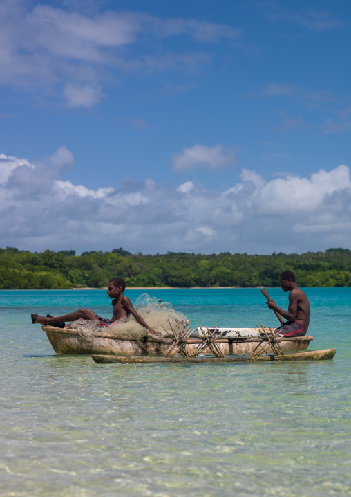 Young boys of the Ni-Vanuatu people paddling in their dugout, Sanma Province, Espiritu Santo, Vanuatu