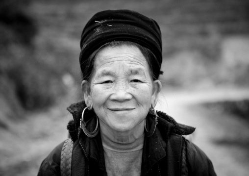 Smiling old black hmong woman with traditional hat and earrings, Sapa, Vietnam