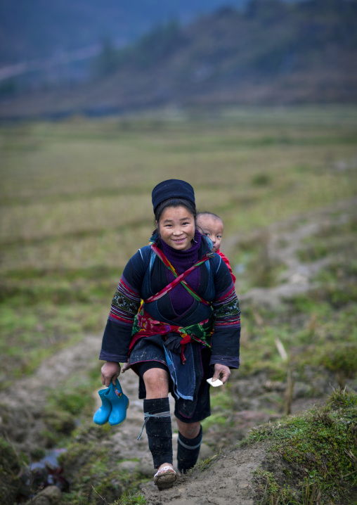 Black hmong girl carrying a baby on her back, Sapa, Vietnam