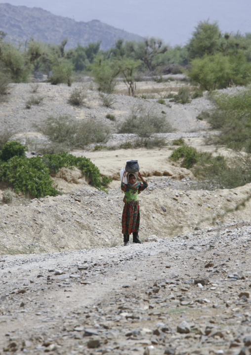Young Girl Carrying Water On A Rocky Track, Shahara, Yemen