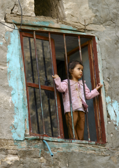 Yemeni girl standing behind a window, Ibb Governorate, Jibla, Yemen