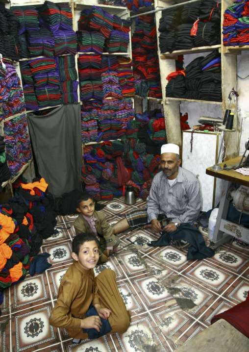 Yemeni man with his children in his fabrics shop, Amanat Al-Asemah, Sanaa, Yemen