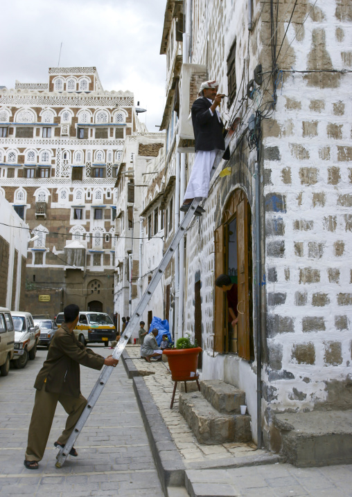 Yemeni man painting a traditional house in the old city, Amanat Al-Asemah, Sanaa, Yemen