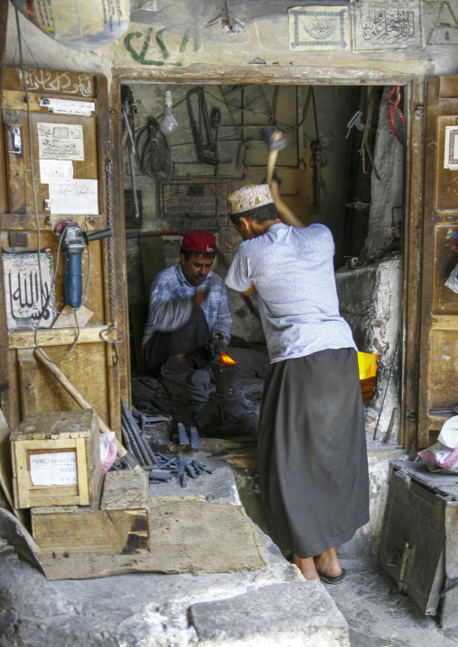 Yemeni blacksmiths working in a workshop, Amanat Al-Asemah, Sanaa, Yemen