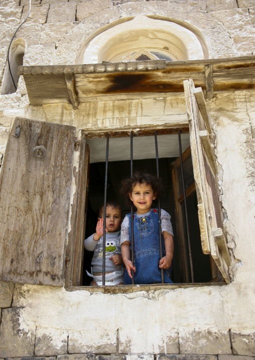 Yemeni girls standing behind a window, Amanat Al-Asemah, Sanaa, Yemen